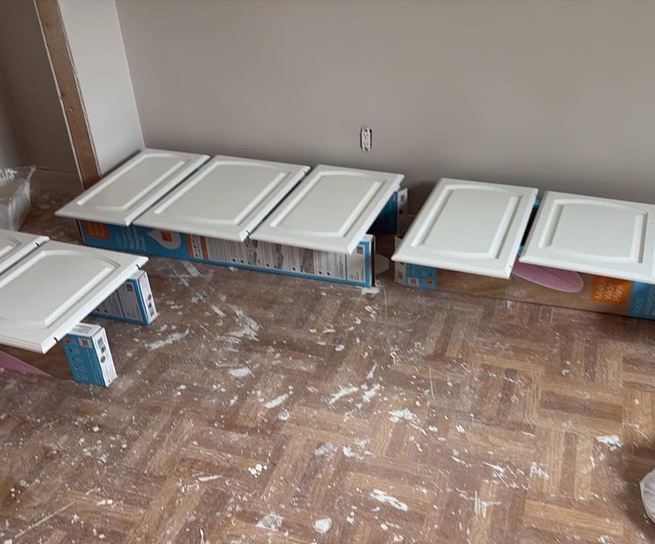 white painted cabinets laid down on the floor